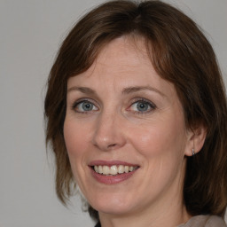 Joyful white adult female with medium  brown hair and grey eyes