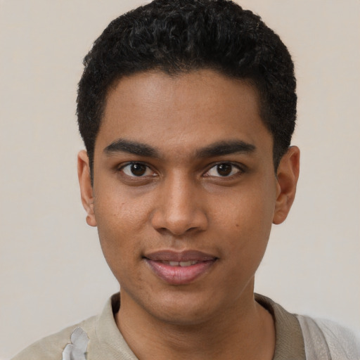Joyful black young-adult male with short  black hair and brown eyes