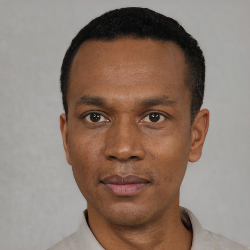 Joyful black young-adult male with short  black hair and brown eyes