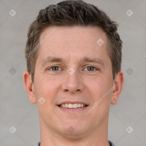 Joyful white young-adult male with short  brown hair and grey eyes