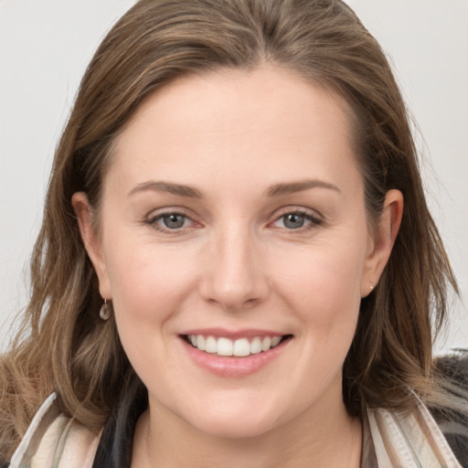 Joyful white young-adult female with long  brown hair and grey eyes