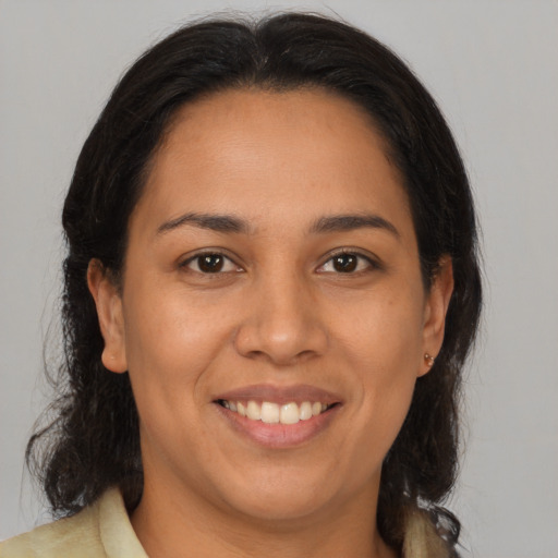 Joyful latino young-adult female with medium  brown hair and brown eyes