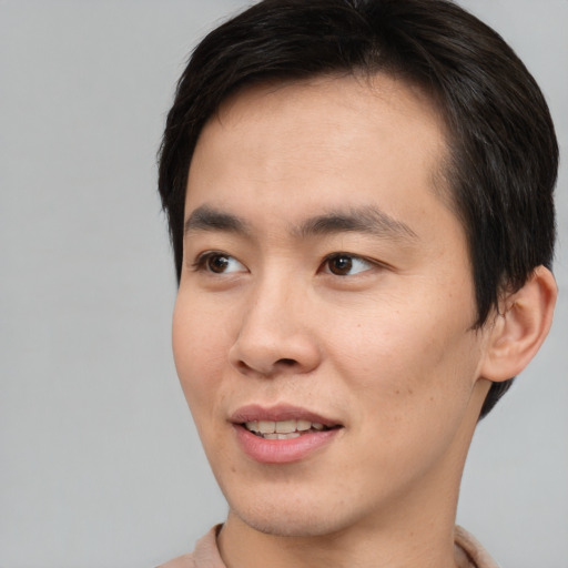Joyful asian young-adult male with short  brown hair and brown eyes