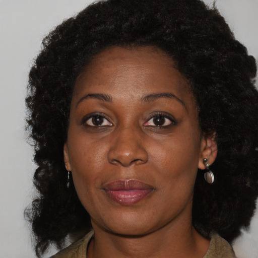 Joyful black adult female with long  brown hair and brown eyes
