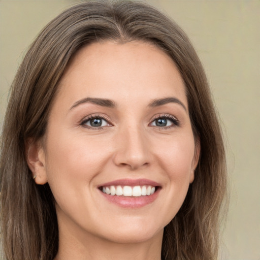 Joyful white young-adult female with long  brown hair and green eyes