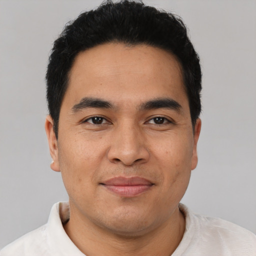 Joyful latino young-adult male with short  black hair and brown eyes