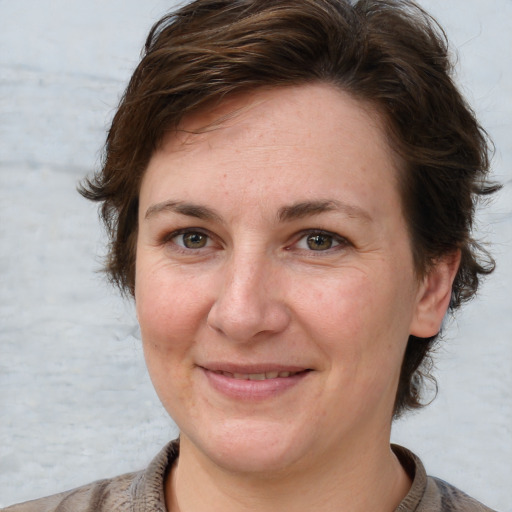 Joyful white adult female with short  brown hair and grey eyes