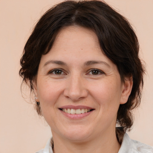 Joyful white adult female with medium  brown hair and brown eyes