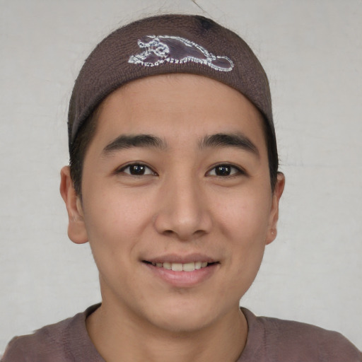 Joyful asian young-adult male with short  brown hair and brown eyes