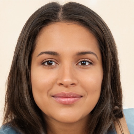 Joyful latino young-adult female with long  brown hair and brown eyes