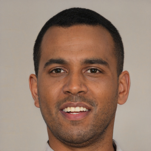 Joyful black young-adult male with short  brown hair and brown eyes