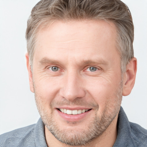 Joyful white adult male with short  brown hair and grey eyes