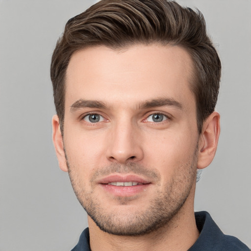 Joyful white young-adult male with short  brown hair and grey eyes