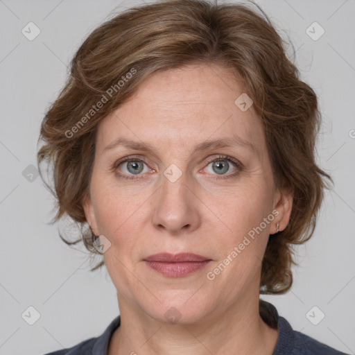 Joyful white adult female with medium  brown hair and blue eyes