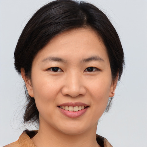 Joyful asian young-adult female with medium  brown hair and brown eyes