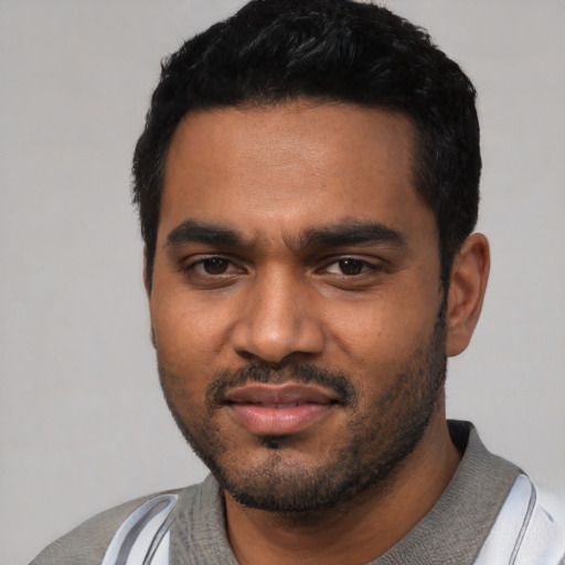 Joyful black young-adult male with short  black hair and brown eyes