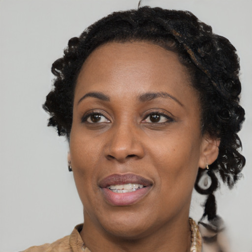 Joyful black adult female with short  brown hair and brown eyes