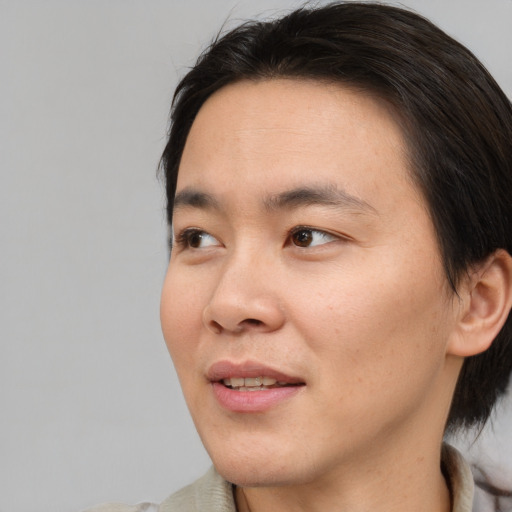 Joyful asian adult male with medium  brown hair and brown eyes