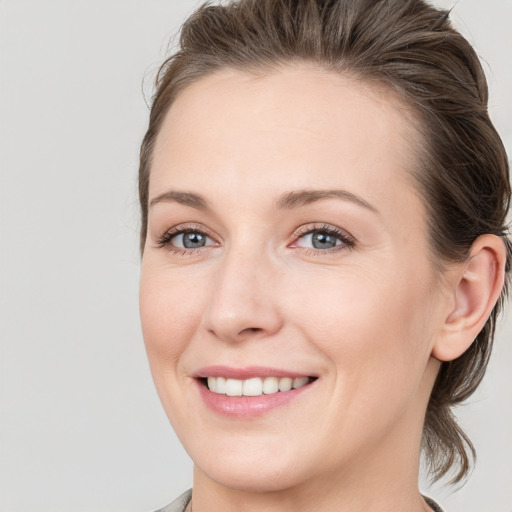 Joyful white young-adult female with medium  brown hair and grey eyes