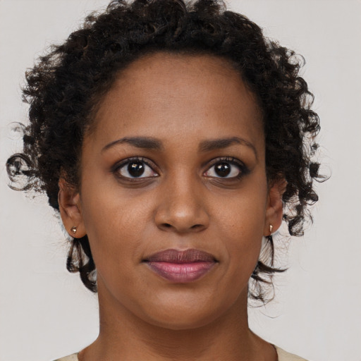Joyful black young-adult female with short  brown hair and brown eyes
