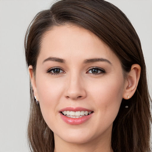 Joyful white young-adult female with long  brown hair and brown eyes