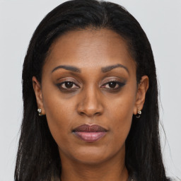 Joyful black young-adult female with long  brown hair and brown eyes