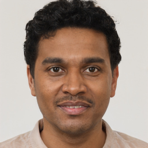 Joyful black young-adult male with short  black hair and brown eyes