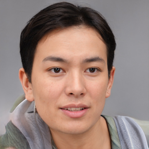 Joyful asian young-adult male with short  brown hair and brown eyes