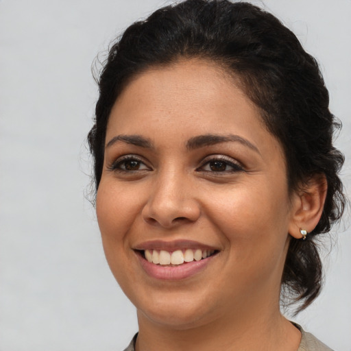 Joyful latino young-adult female with medium  brown hair and brown eyes