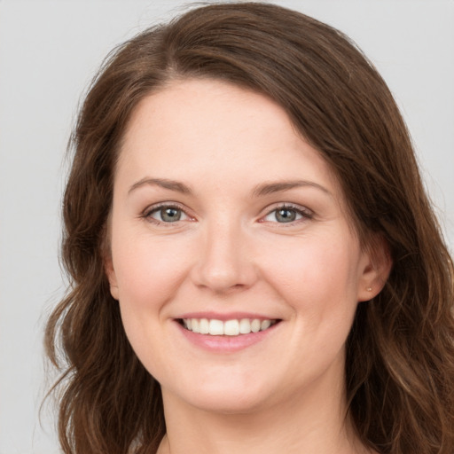 Joyful white young-adult female with long  brown hair and green eyes