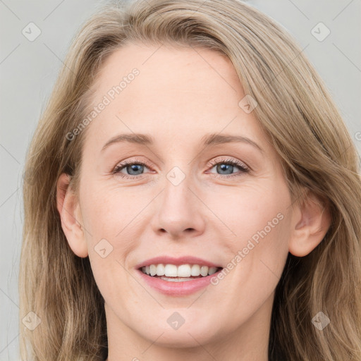 Joyful white adult female with long  brown hair and blue eyes