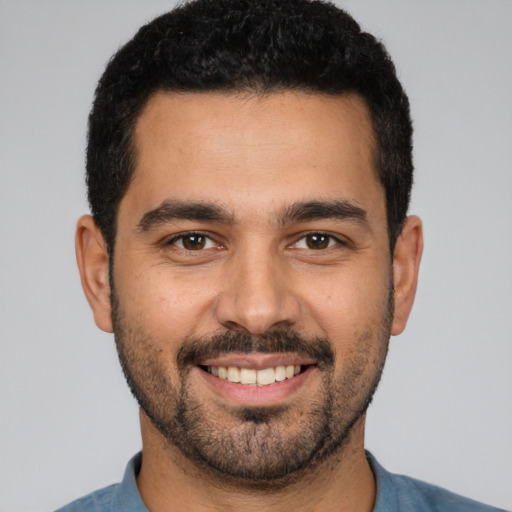 Joyful white young-adult male with short  black hair and brown eyes