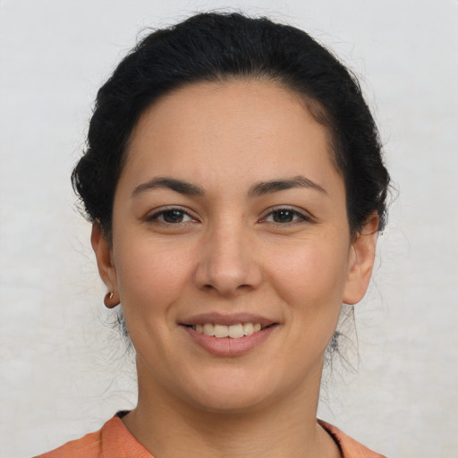 Joyful latino young-adult female with short  brown hair and brown eyes