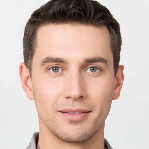 Joyful white young-adult male with short  brown hair and grey eyes