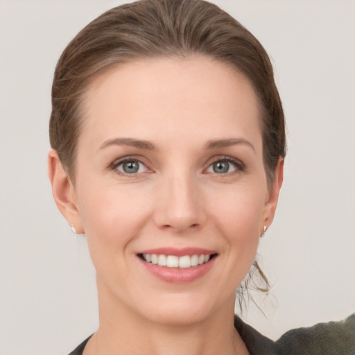 Joyful white young-adult female with short  brown hair and grey eyes