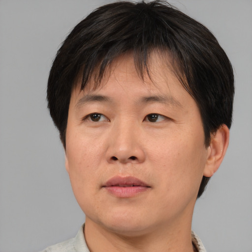 Joyful asian adult male with short  brown hair and brown eyes