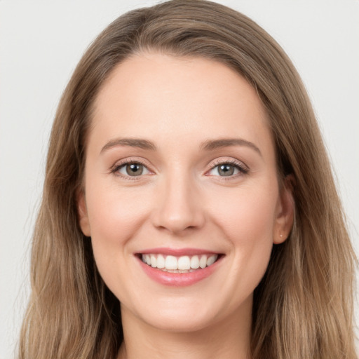 Joyful white young-adult female with long  brown hair and grey eyes