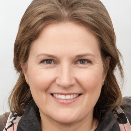 Joyful white adult female with medium  brown hair and grey eyes