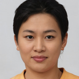 Joyful asian young-adult female with short  brown hair and brown eyes