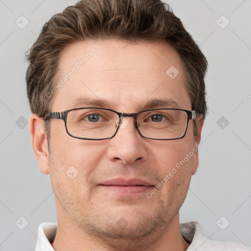 Joyful white adult male with short  brown hair and grey eyes