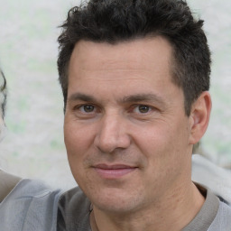 Joyful white adult male with short  black hair and brown eyes