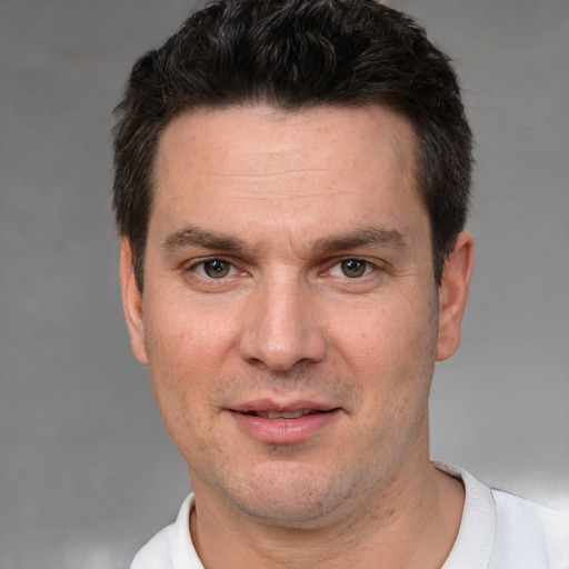 Joyful white adult male with short  brown hair and brown eyes