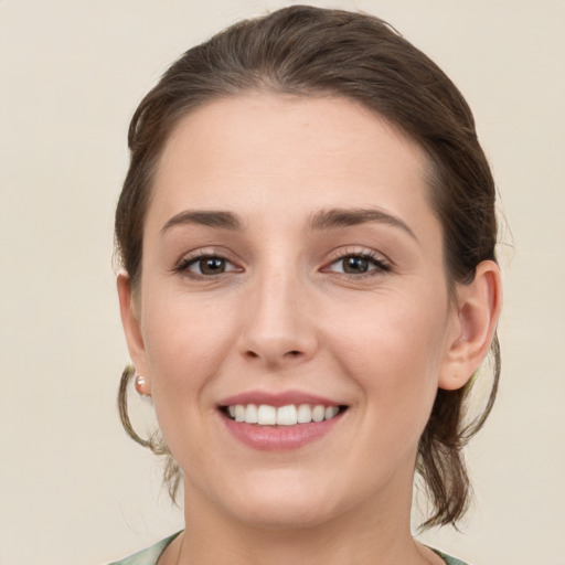 Joyful white young-adult female with medium  brown hair and grey eyes