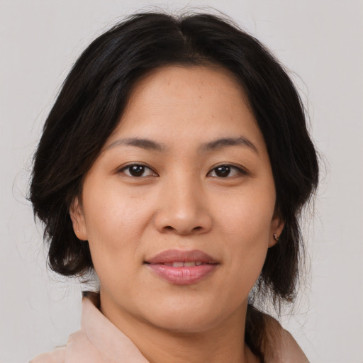 Joyful latino adult female with medium  brown hair and brown eyes