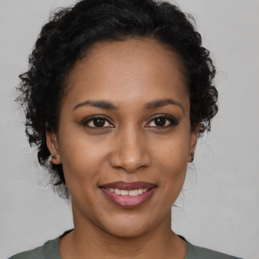 Joyful black young-adult female with short  brown hair and brown eyes