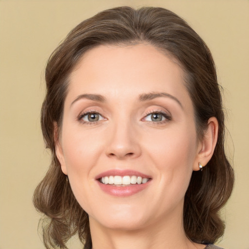 Joyful white young-adult female with medium  brown hair and green eyes