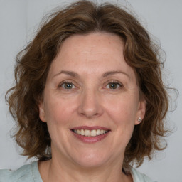 Joyful white adult female with medium  brown hair and blue eyes