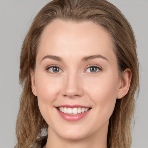 Joyful white young-adult female with long  brown hair and blue eyes