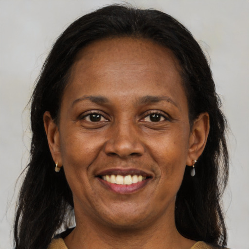 Joyful black adult female with medium  brown hair and brown eyes