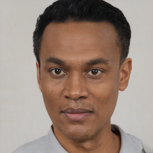 Joyful black young-adult male with short  black hair and brown eyes